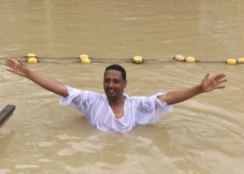 A Christian pilgrim gestures after dipping in the water April 10 at the baptismal site known as Qasr el-Yahud on the Jordan River near the West Bank city of Jericho. (CNS photo/Debbie Hill)