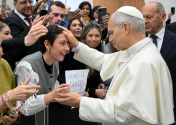 Pope Leo XIV blesses a young woman at the end of his weekly general audience in the Paul VI Audience Hall at the Vatican Jan. 7, 2026. The woman holds a handwritten sign that reads, “Vencí el cáncer” (“I beat cancer”). (CNS photo/Vatican Media)