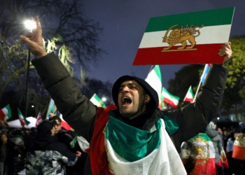 A man gestures while displaying the "Lion and Sun" pre-Iranian Revolution national flag as demonstrators gather outside the Iranian embassy in London Jan. 11, 2026, during a rally in support of nationwide protests in Iran. (OSV News photo/Isabel Infantes, Reuters)