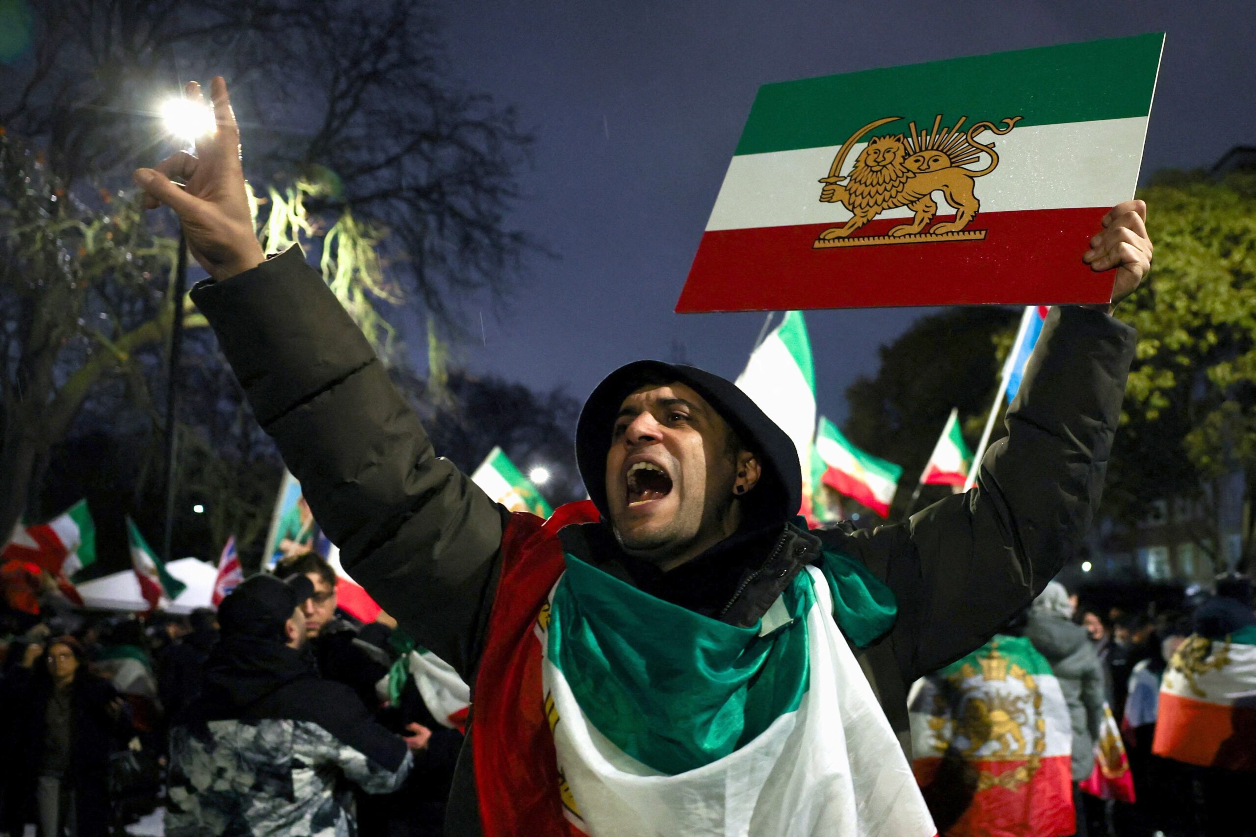 A man gestures while displaying the "Lion and Sun" pre-Iranian Revolution national flag as demonstrators gather outside the Iranian embassy in London Jan. 11, 2026, during a rally in support of nationwide protests in Iran. (OSV News photo/Isabel Infantes, Reuters)