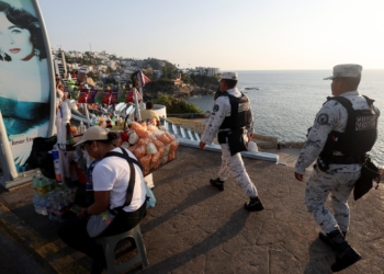 Members of the National Guard walk past people while on patrol, after authorities reinforced security following roadblocks and arson attacks carried out by organised crime in several states, in the aftermath of a military operation in which a Mexican drug lord Nemesio Oseguera, known as "El Mencho," was killed in Jalisco state, in Acapulco, Mexico, Feb. 22, 2026. (OSV News photo/Henry Romeroin, Reuters)
