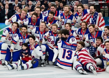 Gold medalists of the U.S. men's hockey team hold up the jersey of the late John Gaudreau and celebrate with his children Noa Harper Gaudreau and Johnny Edward Gaudreau as they pose for a photograph as they celebrate with their medals during the ceremony after defeating Canada 2-1 in overtime during the Milano Cortina 2026 Olympics at Milano Santagiulia Ice Hockey Arena in Milan, Italy, Feb. 22. Gaudreau, and his brother Matthew, who were Catholic, were killed the evening of Aug. 30, 2024, when they were struck by Sean M. Higgins of Woodstown, N.J., a suspected drunk driver, while bicycling in Oldmans Township, close to their hometown in Salem County, N.J. (OSV News photo/Marton Monus, Reuters)