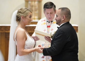 Christina MacDougall places a wedding band on Julio Prendergast's finger as Msgr. Francis J. Schneider officiates their wedding Mass Aug. 20, 2021, at St. John the Baptist Church in Wading River, N.Y. (OSV News photo/Gregory A. Shemitz)