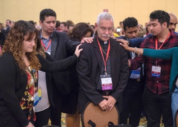 Young Catholic adults are pictured in a file photo praying over Bishop Anthony B. Taylor of Little Rock, Ark., during an evening encounter between young adults and their bishops at the Fifth National Encuentro in Grapevine, Texas. Younger Catholic adults in the U.S. are more likely to be Hispanic or Latino, while just over half of Gen-Z individuals raised Catholic are likely to retain that identity in adulthood, according to a March 23, 2026, data analysis by Mark Gray of the Center for Applied Research in the Apostolate. (OSV News photo/James Ramos, Texas Catholic Herald)