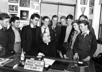 Father Edward Flanagan is surrounded by young men in his office at Boys Town in Omaha, Neb., in this 1942 photo. Pope Leo XIV declared Father Flanagan, the founder of Boys Town, venerable in recognition of his heroic virtue March 23, 2026. (OSV News photo/courtesy Boys Town)