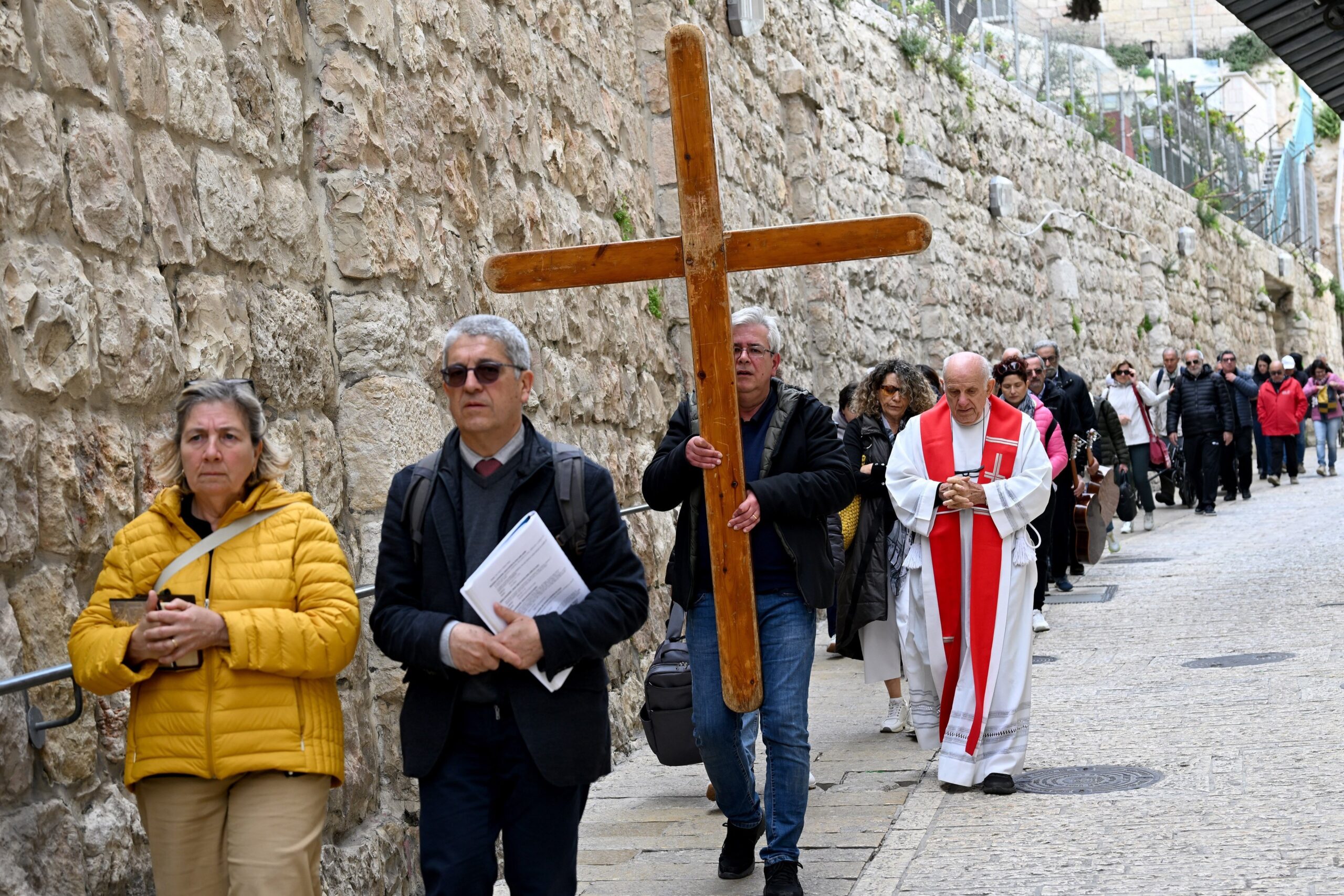 Catholic tourists from Rome carry a cross along the Via Dolorosa, the Way of the Cross, in the Old City of Jerusalem March 23, 2024, the eve of Palm Sunday and the start of Holy Week. (OSV News photo/Debbie Hill)