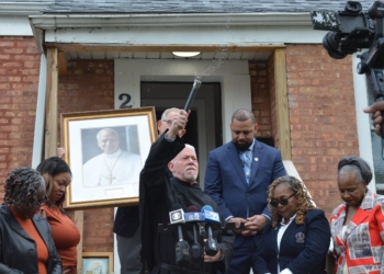 On the steps of Pope Leo XIV’s boyhood home in Dolton, Ill., a suburb of Chicago, Midwest Augustinians outgoing superior, Father Anthony B. Pizzo blesses the crowd after blessing the framed portrait of Pope Leo held by The Pope Leo XIV American Legacy Foundation chairman Vince Kolber, while Village of Dolton Mayor Jason House and his staff bow their heads. (OSV News photo/Simone Orendain)