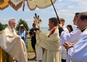 Bishop Joseph Williams receives the Blessed Sacrament from the Diocese of Wilmington’s Bishop William Koenig June 12 at Fort Mott State Park. Photo - Mike Walsh